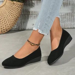 Detail of black suede wedge pumps featuring an elegant pointed toe shown on a model