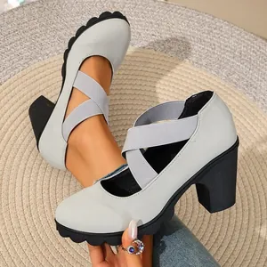 Close-up detail of retro grey Mary Jane shoes with chunky heels and elastic straps.
