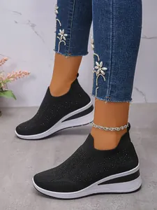 Detailansicht schwarzer Strick-Sneaker mit glitzernden Strasssteinen und Keilsohle