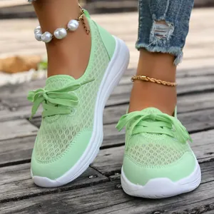 Detail view of mint green mesh walking shoes with lightweight white sole on model.