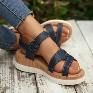 Detailed macro view of stylish navy blue platform sandals featuring cross straps and velcro.