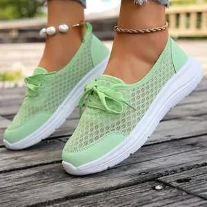 Close-up detail of mint green breathable mesh sneakers featuring flexible white soles