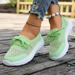 Close-up of mint green breathable mesh slip-on casual shoes for women on wooden deck