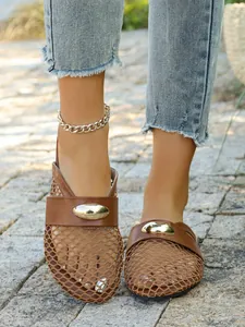 Close-up of brown mesh flat mules featuring breathable fishnet and gold buckle detail