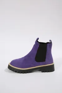 Vista laterale dettagliata di stivaletti Chelsea in camoscio viola con suola carrarmato nera