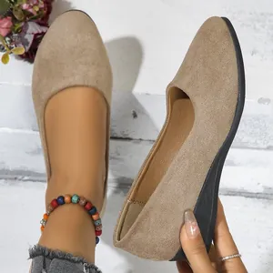 Close-up of tan suede pointed-toe wedge flats with black sole for women
