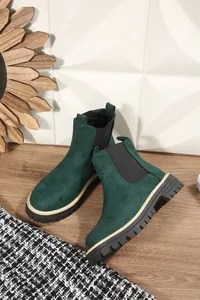 Dettaglio di stivaletti Chelsea in pelle scamosciata verde scuro con suola carrarmato