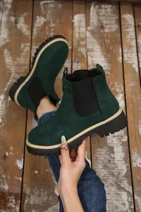 Dettaglio di stivaletti Chelsea in pelle scamosciata verde scuro con suola carrarmato e elastico