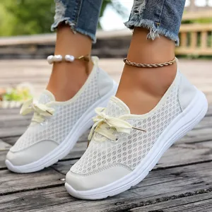 Breathable white mesh sneakers for women, casual flat slip-on shoes with laces.