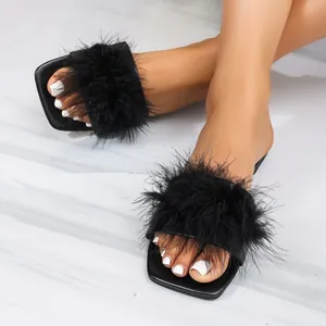 Close-up detail of black fluffy faux fur flat slides with square toe design.