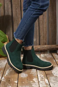 Dettaglio di stivaletti Chelsea da donna in camoscio verde scuro con suola spessa