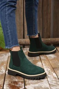 Stivaletti Chelsea da donna in camoscio verde scuro con suole spesse su legno rustico