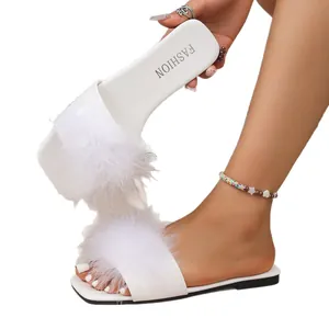 Close-up of white furry flat slides featuring fluffy feather straps for women