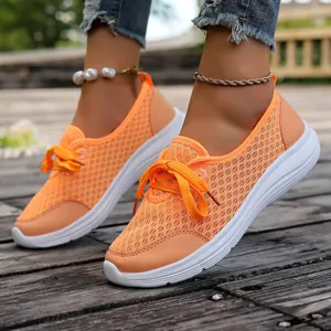 Detail of breathable orange mesh slip-on sneakers for women with white flat soles