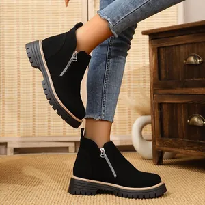 Side view of black round toe ankle boots with metal zipper and chunky lug sole