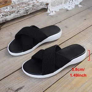 Detail view of the 3.8cm platform heel height on these black cross-strap sandals.