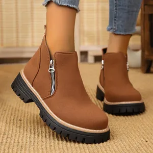 Close-up of brown suede ankle boots with side zipper and chunky platform sole.