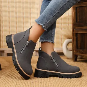 Detail view of grey women's ankle boots with side zipper and thick chunky lug sole.