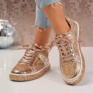 Close-up of women's rose gold glitter sneakers with platform soles and matching laces