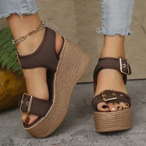 Detailed view of brown platform wedge sandals with braided sole on model feet