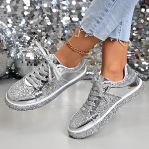 Close-up of women's silver glitter platform sneakers with a metallic finish and laces