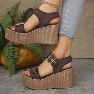 Stylish brown wedge sandals with straw-woven platform soles shown on model's feet.