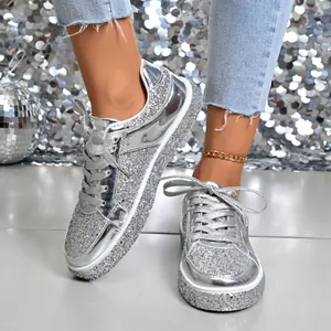 Close-up of women's silver sequin platform sneakers with stylish glitter finish and laces