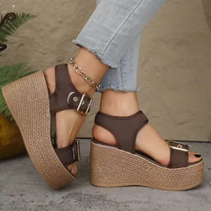 Close-up of stylish brown wedge sandals with straw woven platform and buckle straps