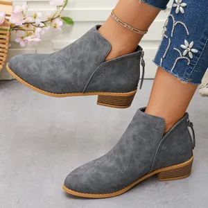 Gros plan de bottines grises à bout pointu avec fermeture éclair à l'arrière.