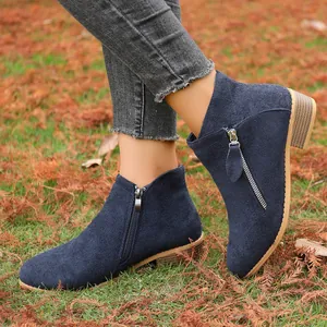 Close-up of navy blue suede ankle boots with side zipper and block heel