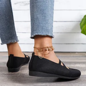 Détail de chaussures plates noires en maille avec une chaîne de cheville dorée élégante
