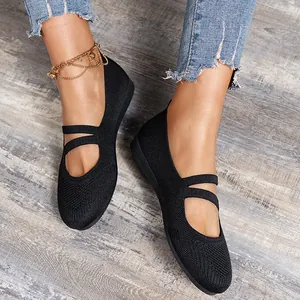 Gros plan détaillé de ballerines noires en maille avec brides croisées sur plancher