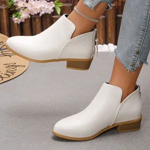 Détail de bottines en cuir blanc à bout pointu avec fermeture éclair au dos et talon épais