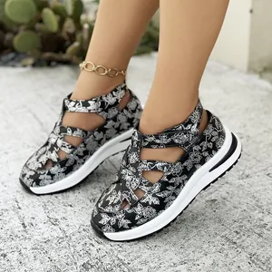 Detailed look at stylish black and white floral print platform sandals on model's feet.