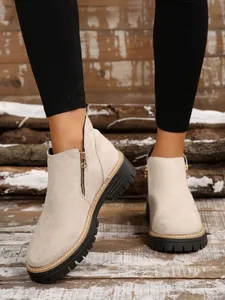 Fashionable beige suede ankle boots with side zipper and chunky black lug sole for women