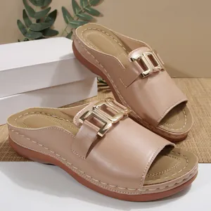 Detailed view of beige wedge slide sandals featuring a stylish gold metal buckle