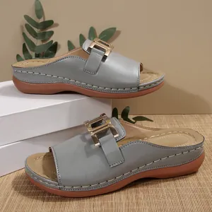 Side view of grey women's wedge slide sandals featuring an elegant gold metal buckle