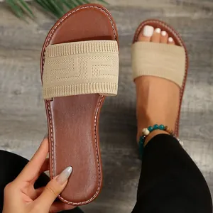 Detalle de la textura de punto y las costuras de las sandalias planas de mujer