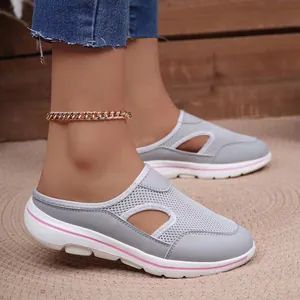 Detail of breathable grey mesh mules with side cutouts and pink accent thick sole.