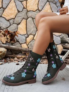 Close-up of floral embroidery detail on dark green western mid-calf knight boots