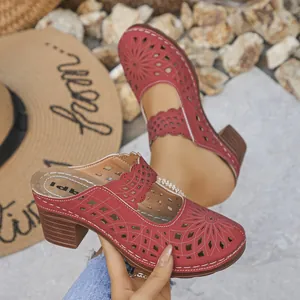 Red laser-cut chunky heel mules featuring floral patterns and a wooden finish heel