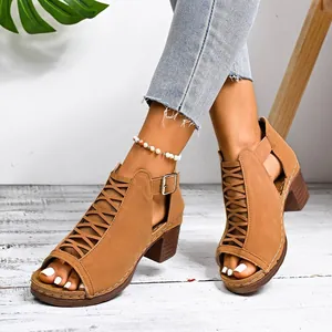 Close-up detail of tan chunky heel Roman sandals with peep-toe and buckle strap