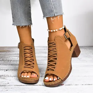Detail view of brown chunky heel Roman sandals featuring a hollow criss-cross lace design.