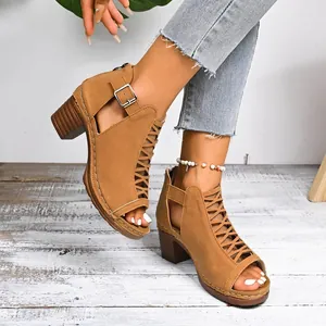 Close-up of brown chunky heel Roman sandals with hollow-out lace and buckle details.