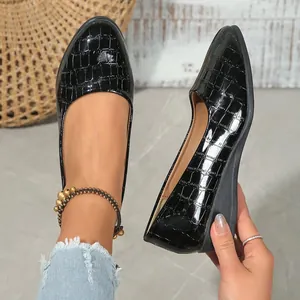 Detailed view of black pointed toe wedge shoes with crocodile embossed pattern.