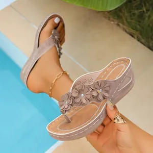 Detailed view of wedge flip-flop sandals featuring three decorative flowers and a thick platform.