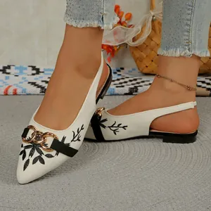 Detailed view of white embroidery pointed-toe slingback sandals with gold chain accent