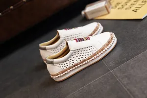 Vue détaillée de mocassins blancs perforés pour femmes avec languette rayée colorée