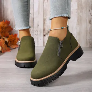Macro view showing the fine green suede texture and side zipper of these ankle boots