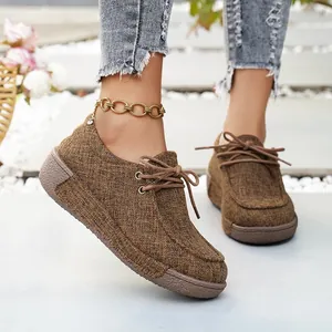 Primer plano de zapatos de plataforma de tela marrón con cordones en pies de modelo